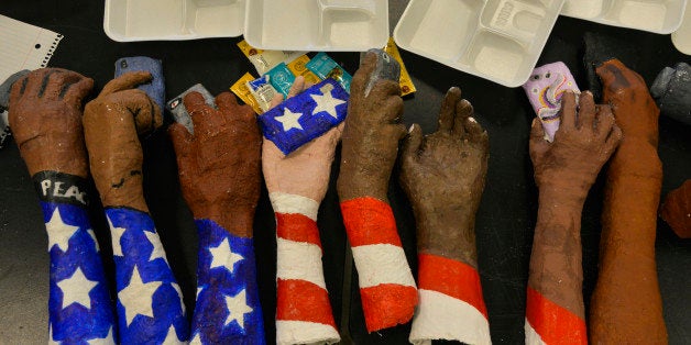ST. LOUIS, MO - NOVEMBER 18: AP Honors students are creating installation art honoring Micael Brown and the town of Ferguson during art class at Riverview Gardens High School on Tuesday, November 18, 2014, in St. Louis, MO. These hands holding cell phones signifies how social media helps spread the news of Michael Brown's shooting and its aftermath. The shooting of Michael Brown, an unarmed black 18-year-old by white Ferguson police officer Darren Wilson, captivated the nation as a grand jury deliberates to decide whether to charge the officer with a crime. Among those most affected by the ongoing unrest are the thousands of high school students in Greater St. Louis, for reasons that include their physical proximity, Browns age. He had just finished summer school classes for his high school diploma days before the shooting. The way this story has existed in the social media worlds where American teens spend hours each day keeps them connected to and in-tuned with the story. The art instructor, Leah Westerfield, wrote, 'Our Superintendent, Dr. Scott Spurgeon, our community Alderwoman Ms Tia Wells, and Assistant Superintendent, Mrs.Tamera Granger stood at my classroom door the Monday afternoon after Michael Brown's death. They asked the eleven talented AP Honors Student Class to create a mural for Peace. The eleven students sat in suspension as the class decision was made to move forward. We sat quietly in a daze at the task. The mural will be 50 feet by 8 feet tall in 14 panels. Upon completion, the mural will be displayed on tour and finally rest in the Ferguson Community. We are hoping to have a panoramic photograph for posturing the mural and a 3 copy documentary of it's making. An art display will accompany it's first reveal.' (Photo by Jahi Chikwendiu/The Washington Post via Getty Images)