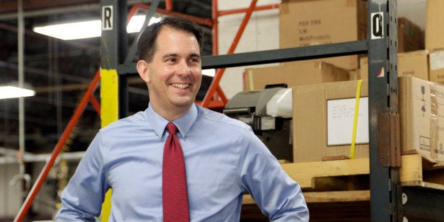 In this Sept. 23, 2014 photo Republican Wisconsin Gov. Scott Walker campaigns for re-election at a manufacturing company in R