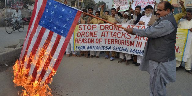 A demonstrator holds up a burning US flag during a protest against drone attacks in Pakistan's tribal region, in Multan on December 6, 2012. A US drone fired two missiles at a compound in Pakistan's northwestern tribal district early December 6, killing at least three militants, local security officials said. The covert US attacks are unpopular in Pakistan, where the government criticises them as a violation of sovereignty but American officials believe they are a vital weapon against Islamist militants. AFP PHOTO/S.S MIRZA (Photo credit should read S.S MIRZA/AFP/Getty Images)