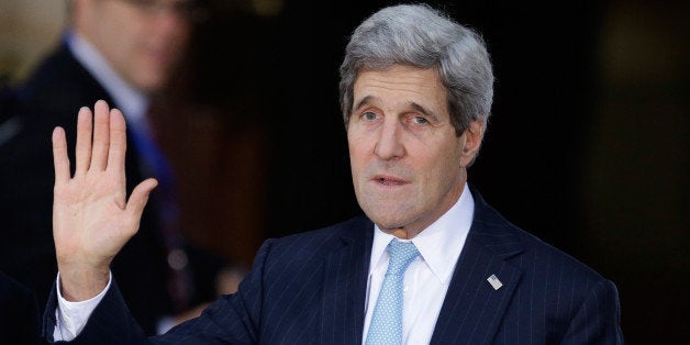 U.S. Secretary of State John Kerry, right, waves at the media as he arrives at Lancaster House for the London Conference on Afghanistan in London, Thursday, Dec. 4, 2014. Afghanistan's leader was asking international politicians on Thursday to stand with his country amid the withdrawal of most foreign troops and a surge in Taliban attacks. Afghan President Ashraf Ghani and British Prime Minister David Cameron jointly hosted a conference in London attended by U.S. Secretary of State John Kerry, Pakistani Prime Minister Nawaz Sharif and diplomats from some 50 countries. (AP Photo/Matt Dunham)