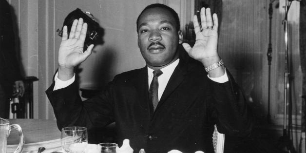 21st September 1963: Black American civil rights leader and Baptist minister Dr Martin Luther King (1929 - 1968) raising his hands in a restaurant. (Photo by William H. Alden/Evening Standard/Getty Images)