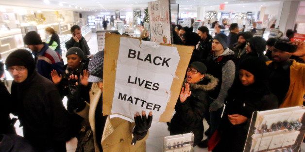 Protesters rallying against a grand jury's decision not to indict the police officer involved in the death of Eric Garner march through Macy's Herald Square, Friday, Dec. 5, 2014, in New York. (AP Photo/Jason DeCrow)