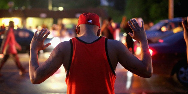 FERGUSON, MO - AUGUST 15: Demonstrators gather along West Florissant Avenue to protest the shooting of Michael Brown on August 15, 2014 in Ferguson, Missouri. Brown was shot and killed by a Ferguson police officer on August 9. Protestors raise their hands and chant 'Hands up, don't shoot' as a rally cry to draw attention to reports that stated Brown's hands were raised when he was shot. Tonight demonstration again ended with protestors clashing with police followed by more looting. (Photo by Scott Olson/Getty Images)