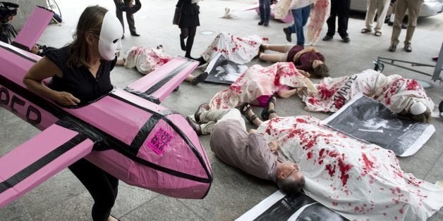 Protestors from Codepink perform mock killings by a woman in a drone costume as they demonstrate the use of military drones by the US goverment outside the Unmanned Systems 2013 exhibition and symposium hosted by The Association for Unmanned Vehicle Systems International (AUVSI) at the Washington Convention Center in Washington, DC, August 13, 2013. The event features more than 8,000 attendees as over 550 exhibitors from around the world display the latest in unmanned systems, robotics and related products, including aerial drones, underwater robots and land-based vehicles, for military, government and commericial use. AFP PHOTO / Saul LOEB (Photo credit should read SAUL LOEB/AFP/Getty Images)