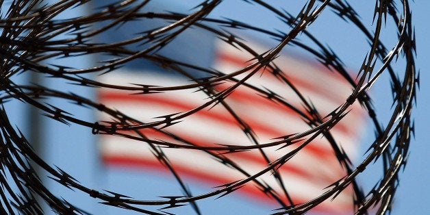 GUANTANAMO BAY, CUBA - OCTOBER 27: (EDITORS NOTE: Image has been reviewed by U.S. Military prior to transmission.) A roll of protective wire rings a detainee camp inside the U.S. military prison for 'enemy combatants' on October 27, 2009 in Guantanamo Bay, Cuba. Although U.S. President Barack Obama pledged in his first executive order last January to close the infamous prison within a year's time, the government has been struggling to try the accused terrorists and to transfer them out ahead of the deadline. Military officials at the prison point to improved living standards and state of the art medical treatment available to detainees, but the facility's international reputation remains tied to the 'enhanced interrogation techniques' such as waterboarding employed under the Bush administration. (Photo by John Moore/Getty Images)