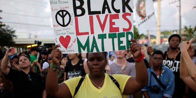 Desiree Griffiths, 31, of Miami, holds up a sign saying "Black Lives Matter", with the names of Michael Brown and Eric Garner