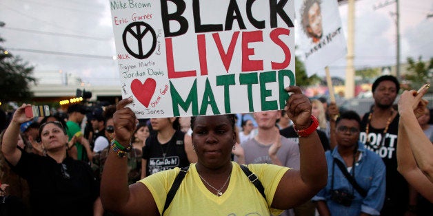 Desiree Griffiths, 31, of Miami, holds up a sign saying "Black Lives Matter", with the names of Michael Brown and Eric Garner, two black men recently killed by police, during a protest Friday, Dec. 5, 2014, in Miami. People are protesting nationwide against recent decisions not to prosecute white police officers involved in the killing of black men. (AP Photo/Lynne Sladky)