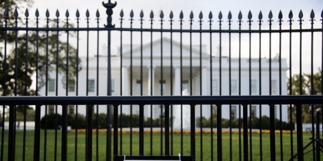 A sign warning of a restricted area is posted on the temporary barricade in front of the fence line to the White House in Washington, DC, October 23, 2014. A suspect who climbed over the White House fence on October 22 was nabbed by Secret Service agents and dogs, a spokesman for the elite agency said. 'At approximately 7:16 pm (1116 GMT), an individual climbed the north fence line of the White House,' the spokesman said. 'The individual was immediately taken into custody on the north lawn of the White House by Secret Service Uniformed Division K-9 teams and Uniformed Division Officers.' The fence climber was identified as 23-year-old Dominic Adesanya from Marlyand, near the US capital, the spokesman said. AFP PHOTO/JIM WATSON (Photo credit should read JIM WATSON/AFP/Getty Images)