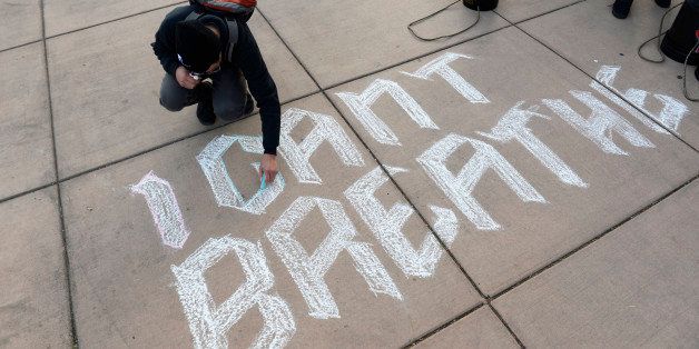 DENVER, CO - DECEMBER 12: Denver School of the Arts student, Zamir Almazbek, draws I Can't Breath on the sidewalk at the City Park Pavilion December 12, 2014. Denver Public School students, organizers and supporters gathered at City Park and then marched towards downtown protesting police brutality in Ferguson, New York and Denver. (Photo by Andy Cross/The Denver Post via Getty Images)