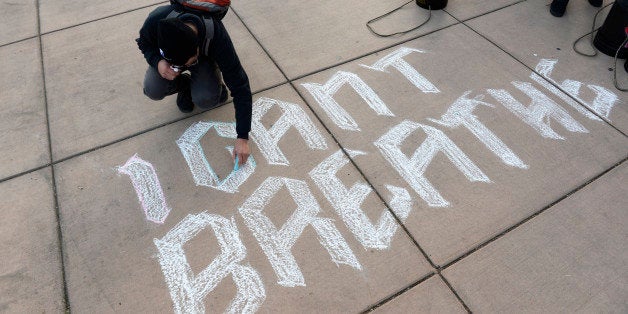 DENVER, CO - DECEMBER 12: Denver School of the Arts student, Zamir Almazbek, draws I Can't Breath on the sidewalk at the City