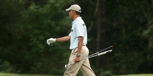 President Barack Obama walks away from a green while golfing at Farm Neck Golf Club, in Oak Bluffs, Mass., on the island of Martha's Vineyard, Sunday, Aug. 17, 2014. In a rare move for him, the president planned a break in the middle of his Martha's Vineyard vacation to return to Washington on Sunday night for unspecified meetings with Vice President Joe Biden and other advisers. (AP Photo/Steven Senne)