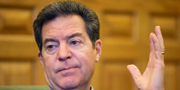 Kansas Gov. Sam Brownback responds to a reporter's question during an interview with The Associated Press at his office in the Statehouse in Topeka, Kan., Wednesday, Dec. 10, 2014. (AP Photo/Orlin Wagner)