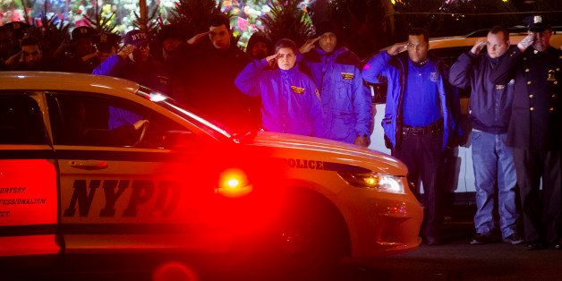 ADDS BOTH OFFICERS KILLED - Mourners stand at attention as the bodies of two fallen NYPD police officers are transported from Woodhull Medical Center, Saturday, Dec. 20, 2014, in New York. An armed man walked up to two New York Police Department officers sitting inside a patrol car and opened fire Saturday afternoon, killing both officers before running into a nearby subway station and committing suicide, police said. (AP Photo/John Minchillo)