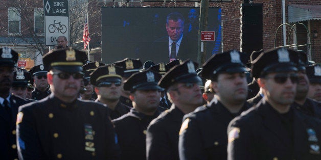 Police officers turn their backs as New York City Mayor Bill de Blasio speaks at the funeral of New York city police officer Rafael Ramos in the Glendale section of Queens, Saturday, Dec. 27, 2014, in New York. Ramos and his partner, officer Wenjian Liu, were killed Dec. 20 as they sat in their patrol car on a Brooklyn street. The shooter, Ismaaiyl Brinsley, later killed himself. (AP Photo/John Minchillo)