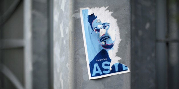 BERLIN, GERMANY - AUGUST 06: Half ripped of flyer with a portrait of Edward Snowden and the request to grant him asylum on A