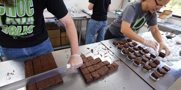 In this Sept. 26, 2014 photo, smaller-dose pot-infused brownies are divided and packaged at The Growing Kitchen, in Boulder. Recreational marijuana sellers are reaching out to novice cannabis users with edible products that impart a milder buzz and make it easy for inexperienced customers to find a dose they are less likely to regret taking. The marketing shift is the pot-industry equivalent of selling beer and wine alongside higher-alcohol options such as whiskey and vodka. (AP Photo/Brennan Linsley)