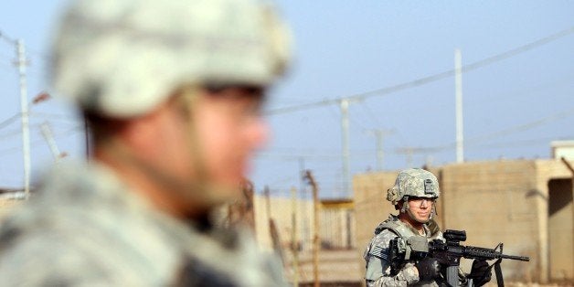 TO GO WITH AFP STORY BY W.G DUNLOP US soldiers stand at the Taji base complex which hosts Iraqi and US troops and is located thirty kilometres north of the capital Baghdad on December 29, 2014. Taji is one of an eventual five sites where the US and allied countries aim to train 5,000 Iraqi military personnel every six to eight weeks for combat against the Islamic State (IS) jihadist group. AFP PHOTO / ALI AL-SAADI (Photo credit should read ALI AL-SAADI/AFP/Getty Images)