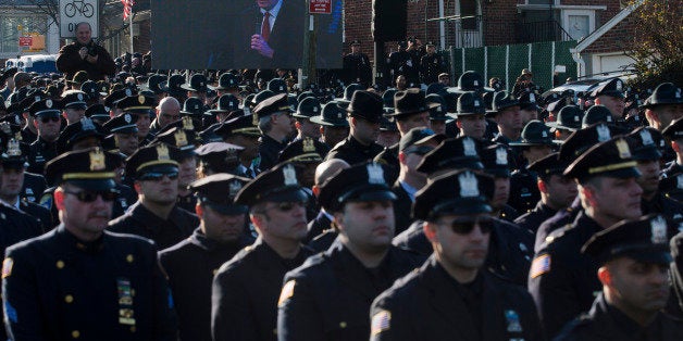 File-This Dec. 27, 2014, file photo shows police officers turning their backs as New York City Mayor Bill de Blasio speaks at