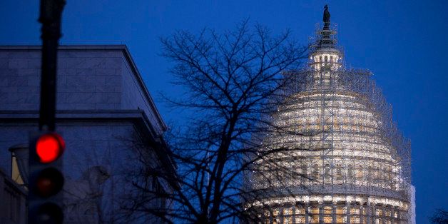 Scaffolding surrounds the U.S. Capitol Building Dome before sunrise in Washington, D.C., U.S., on Wednesday, Dec. 10, 2014. Congress will vote this week on a $1.1 trillion spending plan that would avert a U.S. government shutdown as Democrats agreed to roll back rules affecting banks, clean water and rest for truckers. Photographer: Andrew Harrer/Bloomberg via Getty Images