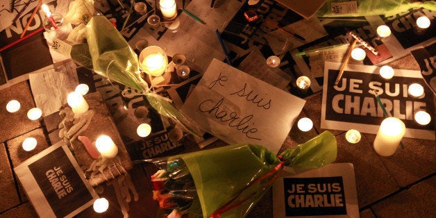 Candles, flowers, pens and placards reading I am Charlie, left by people to show solidarity with those killed in an attack at the Paris offices of weekly newspaper Charlie Hebdo, in Bayonne, southwestern France, Thursday, Jan. 8, 2015. Masked gunmen stormed the Paris offices of a weekly newspaper Charlie Hebdo that caricatured the Prophet Muhammad, killing at least 12 people, including the editor, before escaping in a car. It was France's deadliest postwar terrorist attack. (AP Photo/Bob Edme)