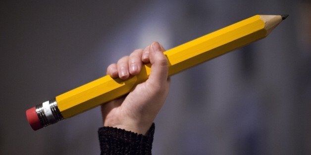 A giant pencil is held up at a vigil outside The French Institute in London on January 9, 2015 for the 12 victims of the atta