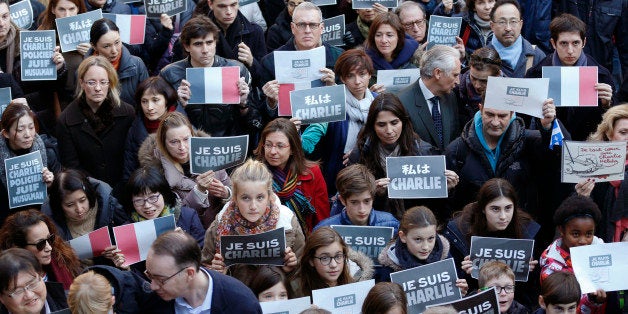 French residents, their family and Japanese hold "Je suis Charlie, or I am Charlie" signs as they attend a special memorial gathering at the French Institute in Tokyo Sunday, Jan. 11, 2015 in support of the victims who were shot by terrorists at the Charlie Hebdo satirical journal in Paris last week. More than 200 people gathered to decry the terrorism in which 17 people and three al-Qaida-inspired gunmen were killed over three days of bloodshed at the offices of the newspaper, a kosher supermarket and other sites around Paris. (AP Photo/Shizuo Kambayashi)