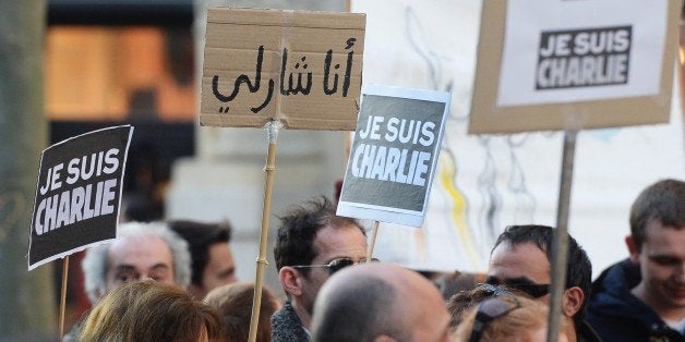 People holds signs that read 'Je suis Charlie' (I am Charlie) in French and Arabic (2nd L) during a rally in Marseille, southeastern France, on January 10, 2015, as tens of thousands of people staged rallies across France following three days of terror and twin siege dramas that claimed 17 victims, including the victims of the first attack by armed gunmen on the offices of French satirical newspaper Charlie Hebdo in Paris on January 7. AFP PHOTO / BORIS HORVAT (Photo credit should read BORIS HORVAT/AFP/Getty Images)