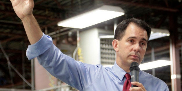In this Sept. 23, 2014 photo Republican Wisconsin Gov. Scott Walker campaigns for re-election at a manufacturing company in R