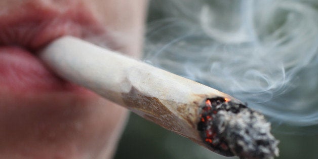 BERLIN, GERMANY - AUGUST 09: A participant smokes a marijuana joint while marching in the annual Hemp Parade (Hanfparade) on August 9, 2014 in Berlin, Germany. Supporters of cannabis legalization are hoping legalized sale in parts of the USA will increase the likelihood of legalization in Germany. The city of Berlin is considering allowing the sale of cannabis in one city district. (Photo by Sean Gallup/Getty Images)