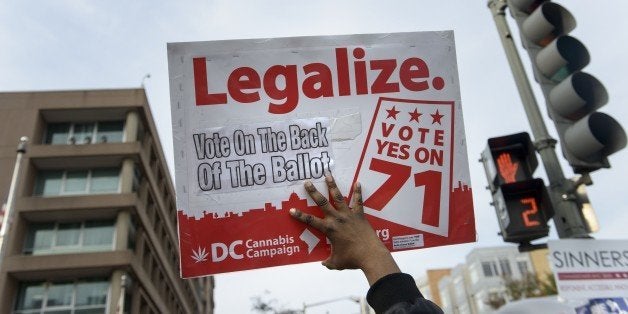 A man holds up a sign for Ballot Initiative #71, the legalization of marijuana, on November 4, 2014 in Washington, DC. Voters around the United States went to the polls to vote in the 2014 interim election. AFP PHOTO/Brendan SMIALOWSKI (Photo credit should read BRENDAN SMIALOWSKI/AFP/Getty Images)