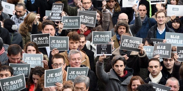 French residents hold signs reading 'Je suis Charlie' (I am Charlie), to pay tribute to the victims of the Charlie Hebdo attack that killed 12 people on January 7, during a photo session at the Institut Francais in Tokyo on January 11, 2015. Over 150 residents gathered at the school to hold a memorial service for the victims. AFP PHOTO / TOSHIFUMI KITAMURA (Photo credit should read TOSHIFUMI KITAMURA/AFP/Getty Images)