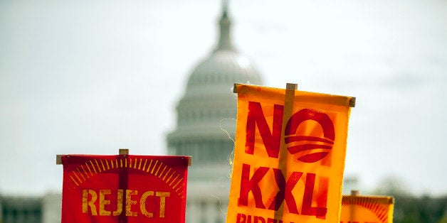 Members of the Cowboy and Indian Alliance (CIA), a group of ranchers, farmers and indigenous leaders hold signs during a protest against the Keystone XL pipeline on the National Mall in Washington, D.C., U.S., on Tuesday, April 22, 2014. TransCanada Corp. is awaiting a U.S. permit to build the northern leg of Keystone XL, which would supply U.S. Gulf Coast refineries with crude from Alberta's oil sands. Because it crosses an international boundary, the proposal requires State Department approval. Photographer: Pete Marovich/Bloomberg via Getty Images