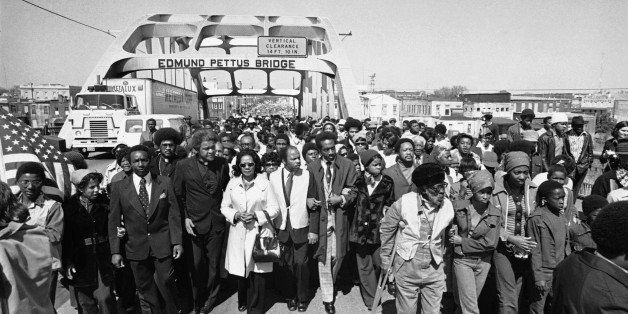 Aided by Father James Robinson, Mrs. Coretta Scott King, widow of Dr. Martin Luther King, Jr., center, and John Lewis of the Voter Education Project, a crowd estimated by police at 5,000, march across the Edmund Pettus Bridge from Selma, Alabama Saturday, March 8, 1975. The march commemorated the decade since the violent struggle for voting rights began in 1965 with âBloody Sundayâ at the bridge as police tried to stop a march to Montgomery. (AP Photo)