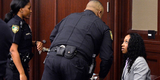 Marissa Alexander, right, listens to a Sheriff's deputy during a hearing Monday, Nov. 24, 2014, in Jacksonville, Fla. Alexander, accused of firing a gun at her estranged husband and his two sons in what she said was self-defense took a plea deal on Monday, in a case that first got attention because her attorneys used Floridaâs âstand your groundâ law in its defense, arguing that she feared for her life before discharging the weapon. She will receive credit for the 1,030 days she has already serve. She must serve 65 more days and will return to jail Monday. Had the 34-year-old Alexander, of Jacksonville, been convicted of all counts at her second trial in the case, set to begin Dec. 1, she would have had to serve 60 years because of Floridaâs minimum-mandatory sentencing rules when a firearm is involved. (AP Photo/The Florida Times-Union, Bruce Lipsky, Pool)