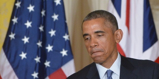 US President Barack Obama pauses during a press conference with Britain's Prime Minister David Cameron in the East Room of th