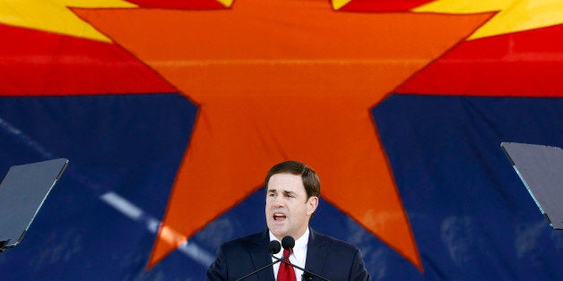 FILE - In this Jan. 5, 2015, file photo, Republican Arizona Gov. Doug Ducey addresses the crowd after being sworn in during inauguration ceremonies at the Arizona Capitol in Phoenix. The Arizona Legislature is putting a bill creating a new high school civics test on the fast track. Gov. Doug Ducey wants the bill to be the first to reach his desk, and the Senate and House education committees have set scheduled hearings for Thursday, Jan. 15, 2015. The bills require students to correctly answer 60 of 100 questions on the civics portion of the test required to become a U.S. citizen in order to graduate. Ducey said Monday that students just arenât learning the basic civics they need to be good citizens. (AP Photo/Ross D. Franklin, File)