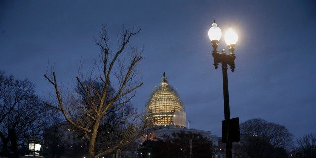 The Capitol in Washington is seen just before dawn as freezing temperatures and snow delay government agencies from opening on time, Tuesday, Jan. 27, 2015. Last night, Democrats temporarily stalled progress on a bill to approve the Keystone XL oil pipeline, the top priority of the Republican-controlled Congress, as they blocked an attempt by GOP leaders to wind down debate. (AP Photo/J. Scott Applewhite)