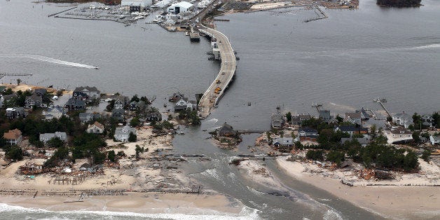 FILE - This Oct. 31, 2012 file aerial photo shows storm damage from Sandy over the Atlantic Coast in Mantoloking, N.J. Climate change is likely to exact enormous costs on U.S. regional economies in the form of lost property, reduced industrial output and more deaths, according to a report backed by a trio of men with vast business experience that was released on Tuesday, June 24, 2014. (AP Photo/Doug Mills, Pool, File)