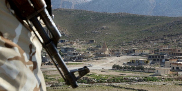 FILE - In this Sunday Jan. 11, 2015 file photo, a Yazidi fighter protects the Sharaf al-Deen temple shrine, one of the holies