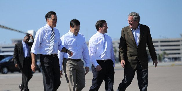 US Republican Presidential candidate Mitt Romney (L) leaves after holding a rally with US Senator Marc Rubio (2nd L), former Florida Governor Jeb Bush (R) and US Congressman Connie Mack at Landmark Aviation in Tampa, Florida, on October 31, 2012. AFP PHOTO/Emmanuel DUNAND (Photo credit should read EMMANUEL DUNAND/AFP/Getty Images)