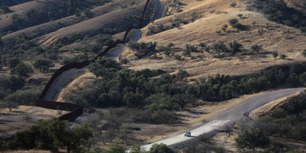 NOGALES, AZ - DECEMBER 09: A U.S. Border Patrol vehicle drives along the U.S.-Mexico border fence on December 9, 2014 near N