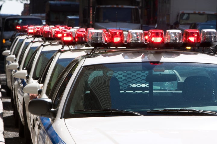 Line of NY Police cars parked with the lights on in a street of Mahattan.