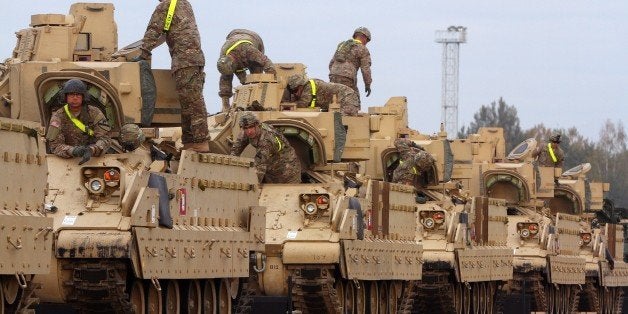 Members of the US Army 1st Brigade, 1st Cavalry Division, transport heavy combat equipment including Bradley Fighting Vehicles at the railway station near the Rukla military base in Lithuania, on October 4, 2014. Lithuania will increase its defence budget by a third next year amid concerns over a resurgent Russia, but spending will still fall short of NATO's recommended two percent of output, officials said on October 2, 2014. AFP PHOTO / PETRAS MALUKAS (Photo credit should read PETRAS MALUKAS/AFP/Getty Images)