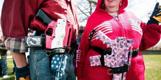 ROMULUS, MI - APRIL 27: Chris (right) and Marty Welch of Cadillac, Michigan, carry decorated Olympic Arms .223 pistols at a rally for supporters of Michigan's Open Carry law April 27, 2014 in Romulus, Michigan. The march was held to attempt to demonstrate to the general public what the typical open carrier is like. (Photo by Bill Pugliano/Getty Images)