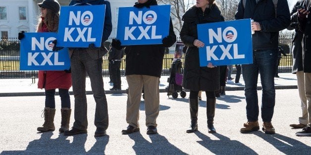 Demonstrators hold signs against the proposed Keystone XL pipeline from Canada to the Gulf of Mexico in front of the White House in Washington, DC, on January 28, 2015. AFP PHOTO/NICHOLAS KAMM (Photo credit should read NICHOLAS KAMM/AFP/Getty Images)