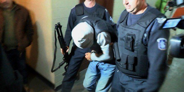This video grab shows Fritz-Joly Joachin, 29, a French citizen of Haitian origin being escorted by Bulgarian police officers in the court in the town of Haskovo, south-eastern Bulgaria on January 13, 2015. A Frenchman arrested in Bulgaria on January 1 trying to cross into Turkey was in contact with one of the men who carried out Islamist attacks in Paris last week, prosecutors said on January 13. Fritz-Joly Joachin, 29, a French citizen of Haitian origin, 'was in contact several times with one of the two brothers -- Cherif Kouachi,' public prosecutor Darina Slavova said. She said these contacts took place before Joachin left France on December 30, a week before Cherif Kouachi and his brother Said killed 12 people in Paris attacks that shocked the world. AFP PHOTO / BGNES --BULGARIA OUT-- (Photo credit should read -/AFP/Getty Images)