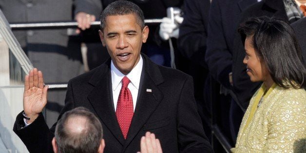 Barack Obama, left, joined by his wife Michelle, takes the oath of office from Chief Justice John Roberts to become the 44th
