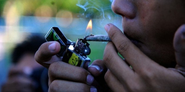 A young man smokes marijuana during a demo for its legalization in front the National congress building in Asuncion, Paraguay, on December 20, 2014 AFP PHOTO / Norberto DUARTE (Photo credit should read NORBERTO DUARTE/AFP/Getty Images)