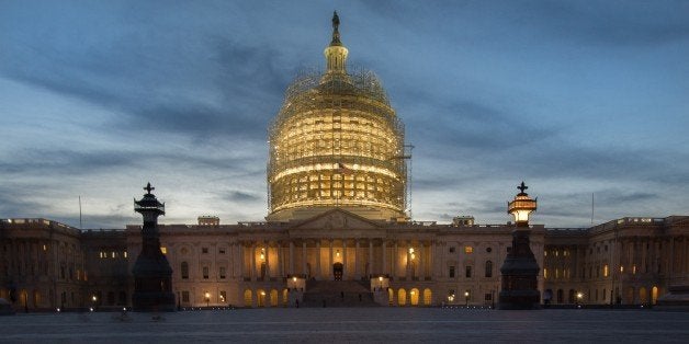 The scaffolded US Capitol is seen at sunset on October 28, 2014 in Washington, DC with a compass marker in the walkway lookin