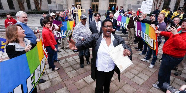 Now legally married, Dinah McCaryer, center, and Olanda Smith, behind McCaryer wearing a hat, are cheered by supporters of gay marriage as they leave the Jefferson County courthouse, Monday, Feb. 9, 2015, in Birmingham, Ala. Alabama began issuing marriage licenses to same-sex couples Monday after the U.S. Supreme Court refused to stop the marriages from beginning in the conservative southern state. (AP Photo/Hal Yeager)